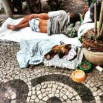Morador de rua com seu cão em Copacabana